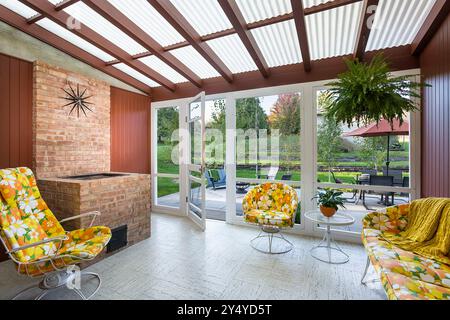 Portico schermato di casa del MidCentury con mobili colorati da patio e grigliate in mattoni Foto Stock