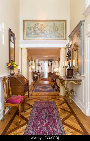 Vista dalla porta d'ingresso del corridoio di casa con spettacolari pezzi d'antiquariato e pavimento in parquet Foto Stock