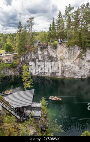 I visitatori apprezzano il canottaggio nelle calme acque del Marble Canyon, abbracciato da impressionanti scogliere e foreste vibranti nel Ruskeala Mountain Park Foto Stock