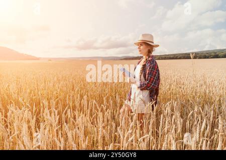 Donna campo di grano. Agronomo, agricoltore donna che controlla i picchi d'orzo maturo dorato nel campo coltivato. Primo piano della mano femminile sulla piantagione in agricoltura Foto Stock