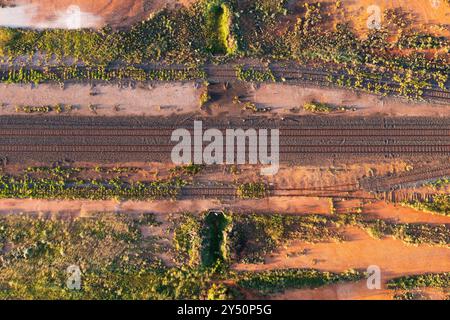 Vista aerea dei binari ferroviari che attraversano un paesaggio rosso dell'entroterra a Cobar nell'Outback New South Wales, Australia. Foto Stock