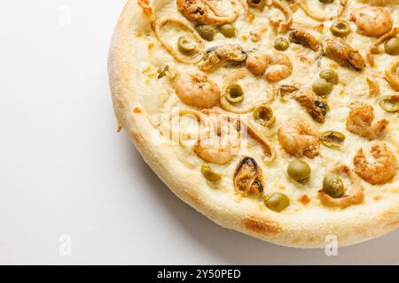 Primo piano di una pizza a base di pesce con gamberi, olive e cipolle su sfondo bianco. Foto Stock