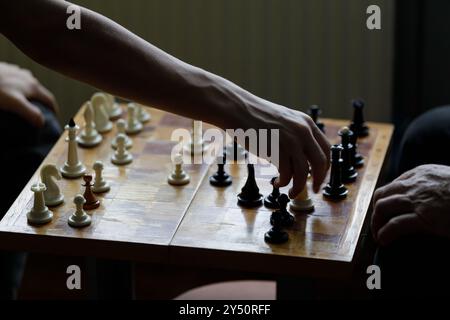 Immagine ravvicinata di due giocatori impegnati in un'intensa partita di scacchi durante un tranquillo pomeriggio Foto Stock