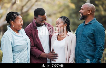 Donna, gravidanza e felice con la famiglia nera in natura per la sicurezza, la cura e l'amore per il futuro bambino. Sorridi, nonni e uomo con la mano incinta Foto Stock