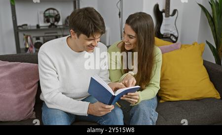 La coppia ama rilassarsi leggendo un libro insieme, comodamente seduti in un soggiorno accogliente e moderno. Foto Stock