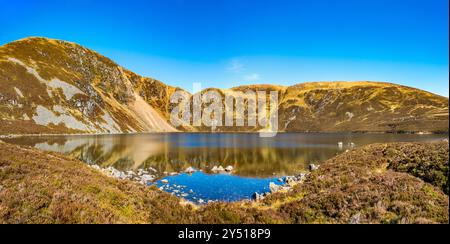 Lo splendido specchio d'acqua chiamato Loch Brandy, un lago di montagna a Glen Clova, Angus, Scozia Foto Stock