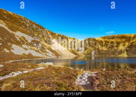 Lo splendido specchio d'acqua chiamato Loch Brandy, un lago di montagna a Glen Clova, Angus, Scozia Foto Stock