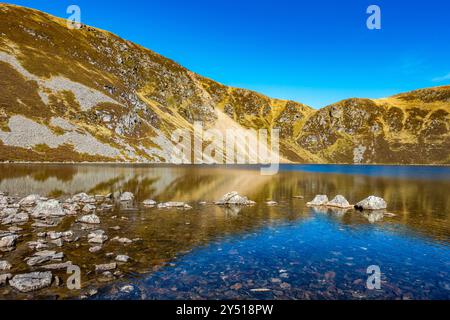 Lo splendido specchio d'acqua chiamato Loch Brandy, un lago di montagna a Glen Clova, Angus, Scozia Foto Stock