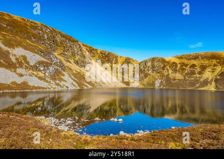 Lo splendido specchio d'acqua chiamato Loch Brandy, un lago di montagna a Glen Clova, Angus, Scozia Foto Stock