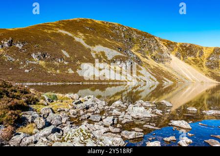 Lo splendido specchio d'acqua chiamato Loch Brandy, un lago di montagna a Glen Clova, Angus, Scozia Foto Stock