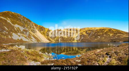 Lo splendido specchio d'acqua chiamato Loch Brandy, un lago di montagna a Glen Clova, Angus, Scozia Foto Stock