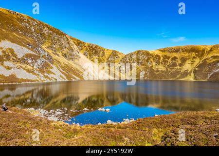 Lo splendido specchio d'acqua chiamato Loch Brandy, un lago di montagna a Glen Clova, Angus, Scozia Foto Stock