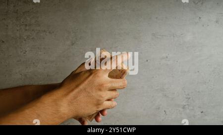 Uomo che detiene una pila di banconote da lira turche in un contesto concreto, evidenziando le transazioni finanziarie e i concetti economici in turchia Foto Stock