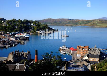 Oban, Scozia, Regno Unito. 20 settembre 2024. Il clima caldo e soleggiato di Oban e sulla costa occidentale, con vista sulla città e sul porto, si prevede che le condizioni di sole continueranno per tutto il fine settimana. Il traghetto Caledonian MacBrayne 'Isola di Mull' attraccato al terminal dei traghetti di Oban e un piccolo traghetto passeggeri in partenza. Vista dalla torre di McCaig. Crediti: Craig Brown/Alamy Live News Foto Stock