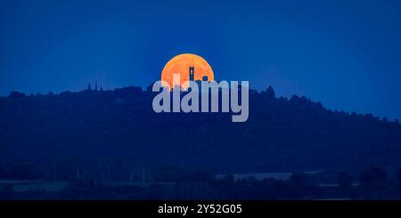 Luna piena sorge dietro il santuario di la Guàrdia (Sagàs), visto dalla cappella di Sant Marc, a Cal Bassacs, Gironella (Berguedà, Catalogna, Spagna) Foto Stock