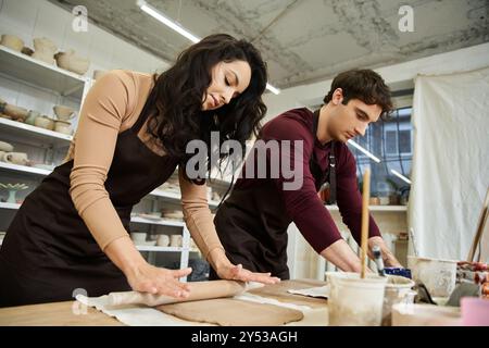 Un paio di persone modellano con gioia l'argilla sul banco di lavoro in ceramica. Foto Stock