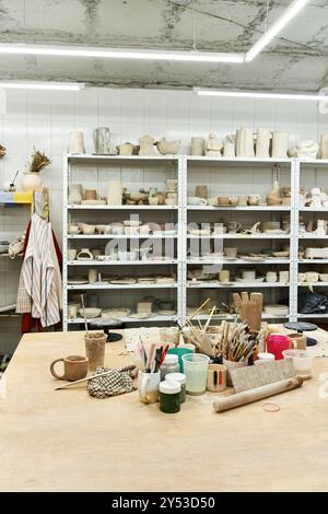 Spazioso studio di ceramica con tavolo e pentole. Foto Stock