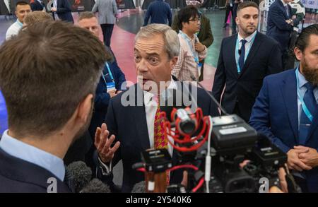 20 settembre 2024, Birmingham, Regno Unito. Nigel Farage arriva alla CONFERENZA SULLE RIFORME 2024 affiancata dalla sicurezza e seguita dalla stampa. Birmingham, NEC. Credito britannico: GaryRobertsphotography/Alamy Live News Foto Stock