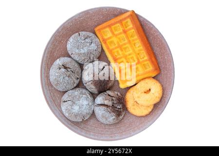 Ampia scelta di torte e waffle in un piatto di ceramica. Isolare su sfondo bianco. Biscotto romantico dorato. Foto Stock