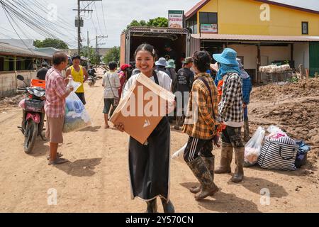 Chiang Rai, Thailandia. 18 settembre 2024. Una giovane donna sorride dopo un'associazione che aiuta le vittime dell'alluvione, le ha dato una scatola di vestiti di seconda mano, a Chiang Rai City, Thailandia. A Chiang Rai sono in corso interventi di restauro a seguito delle peggiori inondazioni degli ultimi 80 anni, con persone che affrontano l'estesa pulizia di fango e detriti spessi che hanno superato l'area. Molti residenti sono stati costretti ad evacuare a causa di case strutturalmente non sicure, lasciando dietro di sé una scia di distruzione causata dalle inondazioni. (Foto di Nathalie Jamois/SOPA Images/Sipa USA) credito: SIPA USA/Alamy Live News Foto Stock