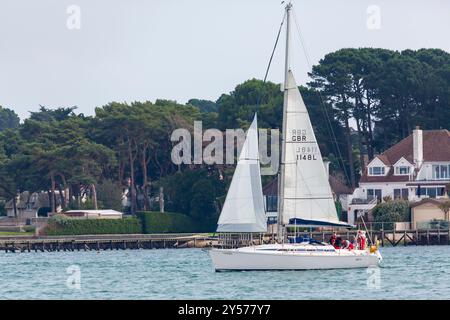 Poole, Dorset, Regno Unito. 20 settembre 2024. Meteo nel Regno Unito: Caldo e umido a Poole, nel Dorset, con un avvertimento meteorologico giallo emesso per Dorset per temporali e forti piogge e anche la possibilità di un tornado riportato sul giornale locale. I marinai sfruttano al massimo la brezza e le condizioni del vento nel porto di Poole, passando davanti a proprietà sul lungomare che valgono milioni di dollari a Sandbanks. Crediti: Carolyn Jenkins/Alamy Live News Foto Stock