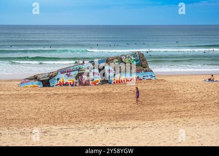 Capbreton, Nouvelle-Aquitaine / Francia- 09/03/2023: Bunker dipinto e camminatore sulla spiaggia di Capbreton nelle Landes in Francia Foto Stock