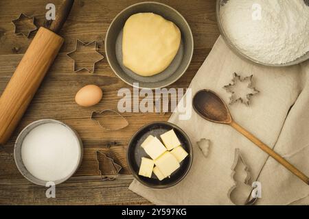 Raccolta di ingredienti e utensili per cuocere i biscotti natalizi su uno sfondo di legno scuro Foto Stock