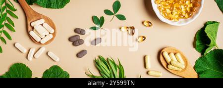 Integratori vegetali. Vitamine organiche. Omeopatia e erboristeria alternativa. Capsule e pillole vegane, foglie vegetali verdi su backgroun beige Foto Stock