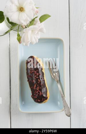 Eclair con glassa al cioccolato con topping di lampone Foto Stock