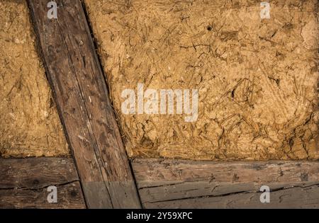 Casa di argilla a parete, con dettagli sulle travi di legno e la miscela di fango e paglia, perfetto come sfondo Foto Stock