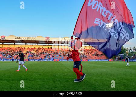 Unterhaching, Deutschland. 20 settembre 2024. DAS Unterhachinger Maskottchen FONSI läuft vor dem Spiel mit Haching-Fahne über den Platz, 20.09.2024, Unterhaching (Deutschland), Fussball, 3. LIGA, SPVGG UNTERHACHING - FC ERZGEBIRGE AUE, LE NORMATIVE DFB/DFL VIETANO QUALSIASI USO DI FOTOGRAFIE COME SEQUENZE DI IMMAGINI E/O QUASI-VIDEO. Credito: dpa/Alamy Live News Foto Stock