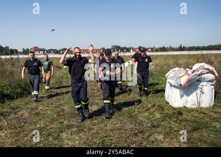 I vigili del fuoco fuggono dall'eliporto prima che un Falco Nero entrasse nell'eliporto temporaneo di Lewin Brzeski. Nella Polonia sudoccidentale, forti piogge e cicloni che attraversano l'Europa centrale hanno portato a gravi inondazioni. Fiumi come l'Odra, Bystrzyca o Nysa K?odzka a Kantorowice e la città di Lewin Brzeski hanno sperimentato un brusco aumento del livello dell'acqua, causando numerose inondazioni e la rottura di argini alluvionali. Le autorità stanno lavorando per gestire la situazione, con sforzi continui per prevenire ulteriori danni. Foto Stock