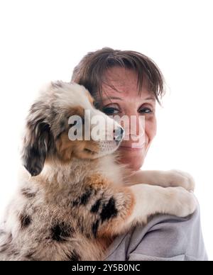 donna e pastore australiano davanti a sfondo bianco Foto Stock