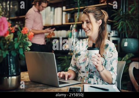 Caffè, computer portatile e sorrisi con una fioraia alla scrivania in piccole imprese per l'amministrazione o l'e-commerce. Computer, bevande alcoliche e ordini online Foto Stock
