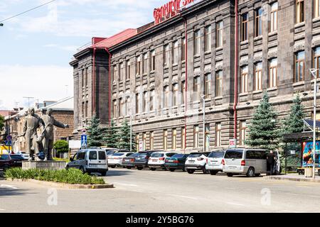 Gyumri, Armenia - 20 luglio 2024: Costruzione del Centro tecnologico Gyumri e statua di due ghisani raffiguranti Sheram e Jivani nella città di Gyumri sulla soleggiata somma Foto Stock