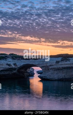 Arco di S Archittu, un arco roccioso alto 17 metri, risultato dell'erosione marina di un'antica grotta formata nel calcare, al tramonto. S Archittu Sardegna Foto Stock