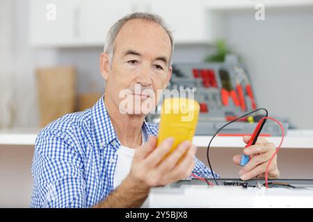 un elettricista anziano al lavoro Foto Stock