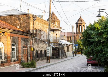 Case residenziali e chiesa in via Abovyan nella città vecchia di Gyumri, Armenia al tramonto estivo Foto Stock