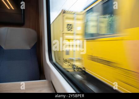 Un treno merci che passa per un treno passeggeri visto attraverso il finestrino del treno passeggeri, Regno Unito Foto Stock