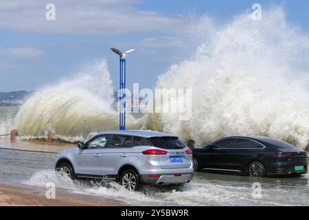 YANTAI, CINA - 21 SETTEMBRE 2024 - le automobili passano una sezione coperta di acqua marina sulla Binhai North Road a Yantai, nella provincia di Shandong della Cina orientale, 2 settembre Foto Stock