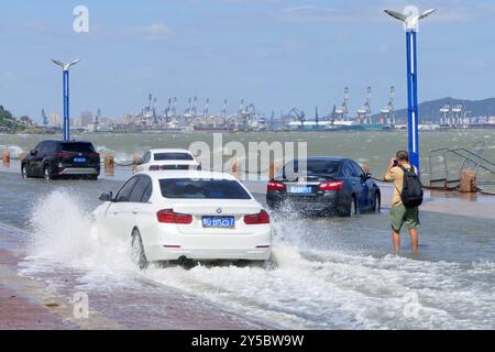 YANTAI, CINA - 21 SETTEMBRE 2024 - le automobili passano una sezione coperta di acqua marina sulla Binhai North Road a Yantai, nella provincia di Shandong della Cina orientale, 2 settembre Foto Stock