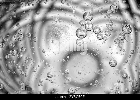 L'olio cade in un bicchiere d'acqua Foto Stock