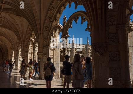 I turisti camminano sul balcone del Monastero di Jerónimos che mostra intricate incisioni in pietra, il Monumento Nazionale e il sito Patrimonio dell'Umanità dell'UNESCO. Foto Stock