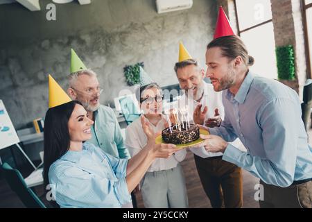 Ritratto dei lavoratori professionisti del gruppo che si congratulano con i colleghi per la torta di compleanno nel business center interno Foto Stock