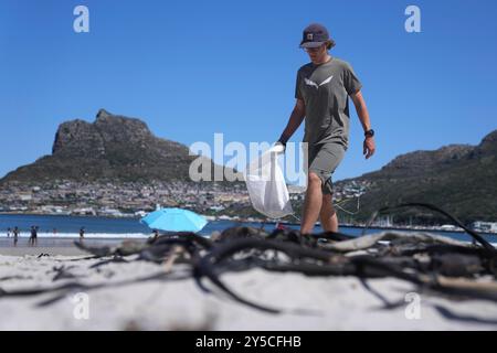 Giornata mondiale della pulitura a città del Capo, Sud Africa Un volontario raccoglie i rifiuti di plastica al largo della spiaggia di Hout Bay durante una pulizia della spiaggia per celebrare la giornata mondiale della pulitura a città del Capo, Sud Africa, il 21 settembre 2024. La giornata mondiale della pulitura è un programma d'azione sociale globale annuale volto a combattere il problema globale dei rifiuti solidi, compreso il problema dei detriti marini. Ci sarà più plastica nell'oceano che pesce entro il 2050 secondo un rapporto della Ellen MacArthur Foundation. La combinazione delle vaste coste africane, dei limitati sistemi di gestione dei rifiuti e della continua produzione di plastica nel Foto Stock