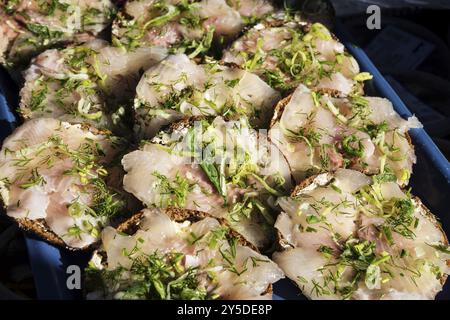 Mini panini con filetto di aringa scandinavo fresco marinato con aneto al mercato di helsinki Foto Stock