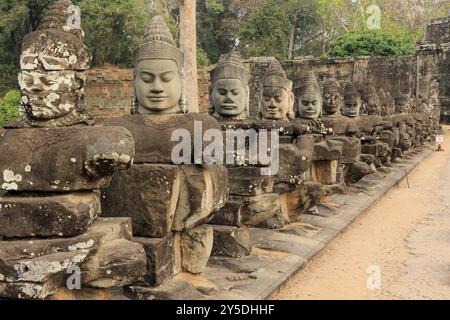 Balaustra con divinità e demoni di pietra sul ponte verso il Tor Tor meridionale di Angkor Thom Foto Stock