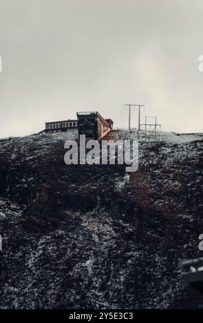 Stazione della funivia sulla cima della montagna rocciosa artica innevata sopra Tromso, Norvegia Foto Stock