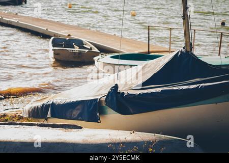 Barche che riposano sulla riva di un lago artificiale calmo Foto Stock