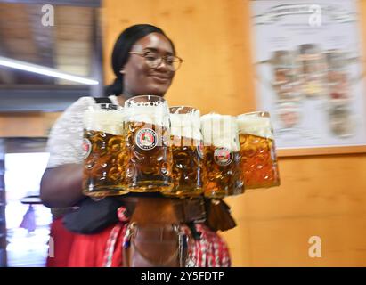 Monaco, Germania. 21 settembre 2024. Un membro del personale serve birra durante l'Oktoberfest a Monaco, Germania, 21 settembre 2024. Il 189esimo Oktoberfest, uno dei più grandi festival popolari in Germania, è stato inaugurato sabato a Monaco di Baviera, con il sindaco Dieter Reiter che spillava il primo barile di birra come tradizione. Il festival di quest'anno durerà fino al 6 ottobre. Crediti: Ren Pengfei/Xinhua/Alamy Live News Foto Stock